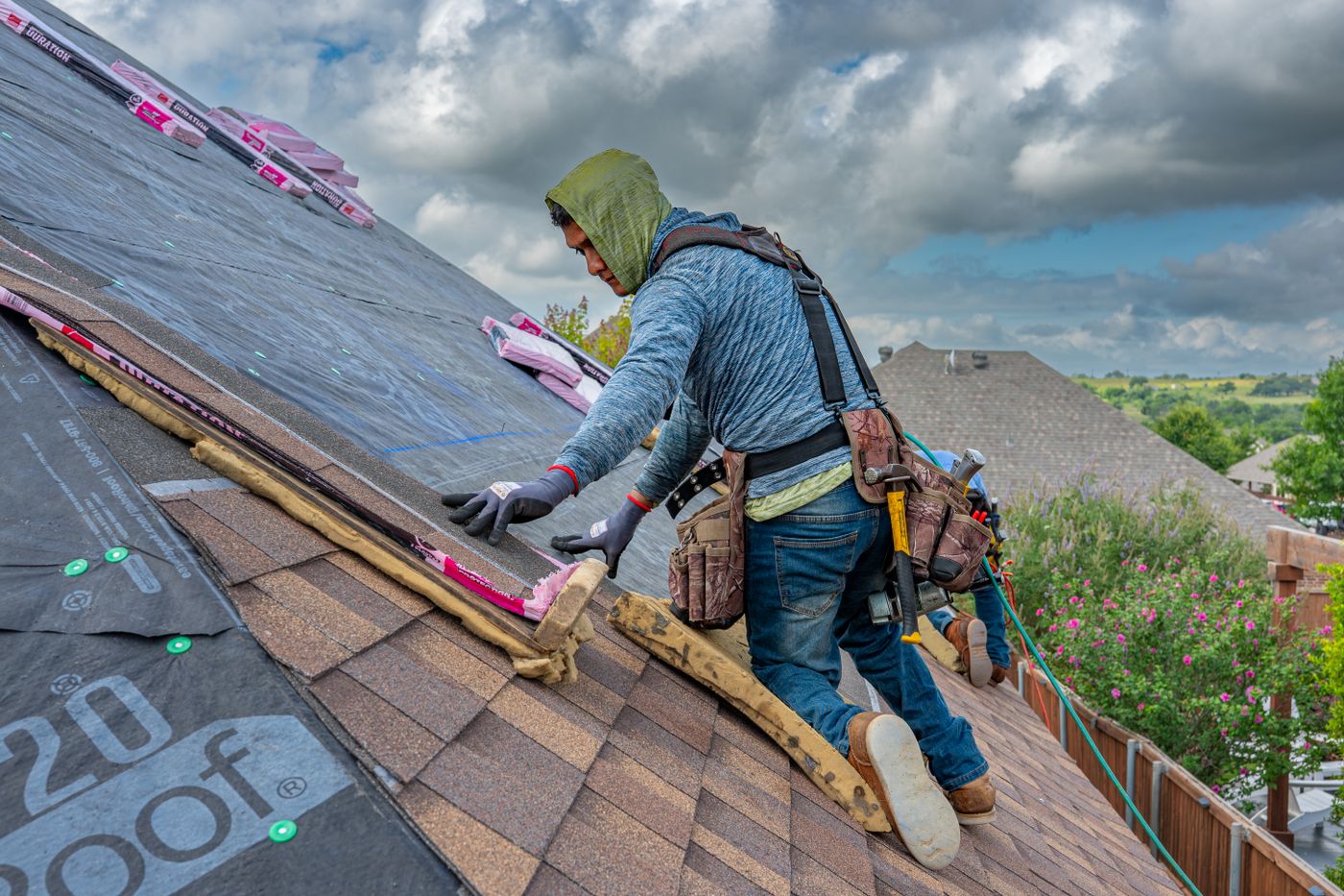Professional roofer installing shingles on a home